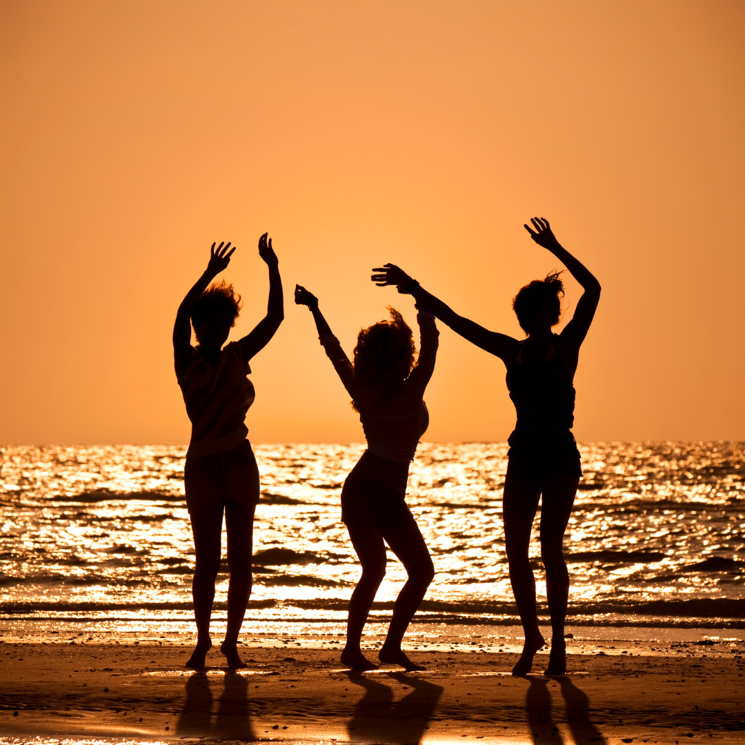 Women dancing on the beach